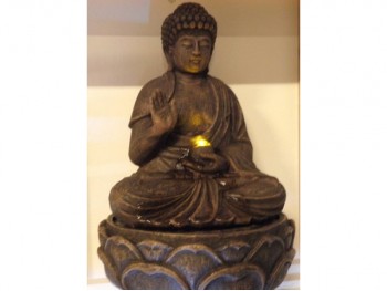Budha med lys og rindende vand